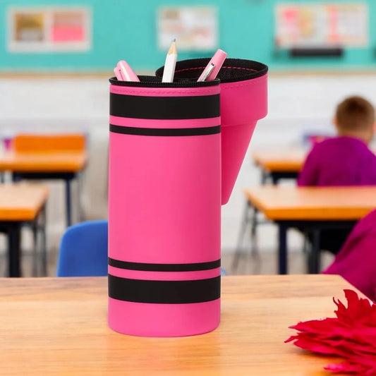 Pink crayon-shaped pencil holder with pens on a classroom desk