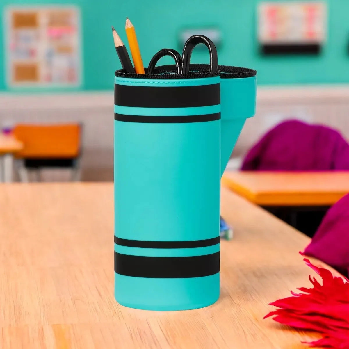 Turquoise pencil holder with black stripes on a classroom desk