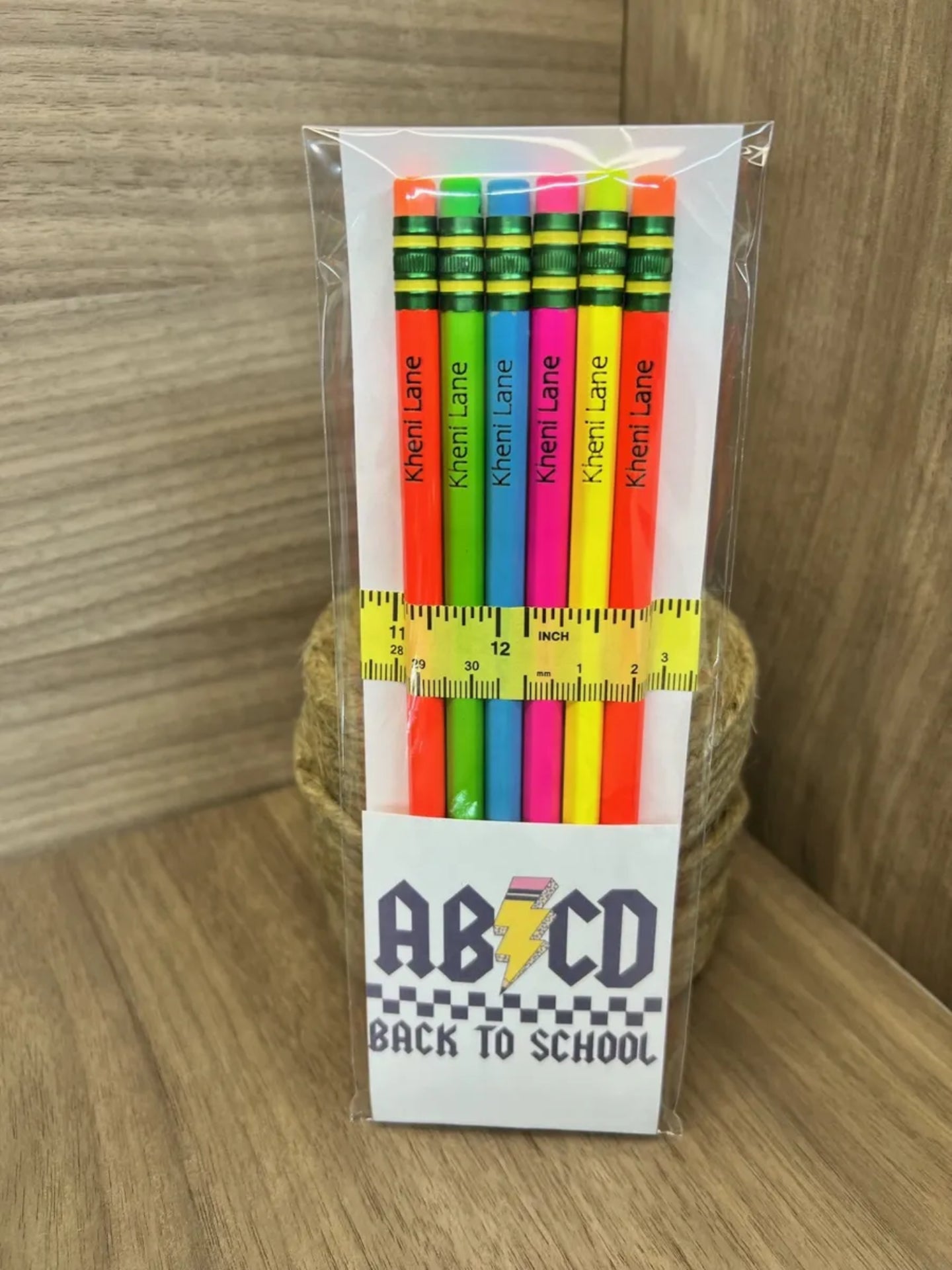 Packaged colorful pencils with a ruler and 'Back to School' text on a wooden surface.
