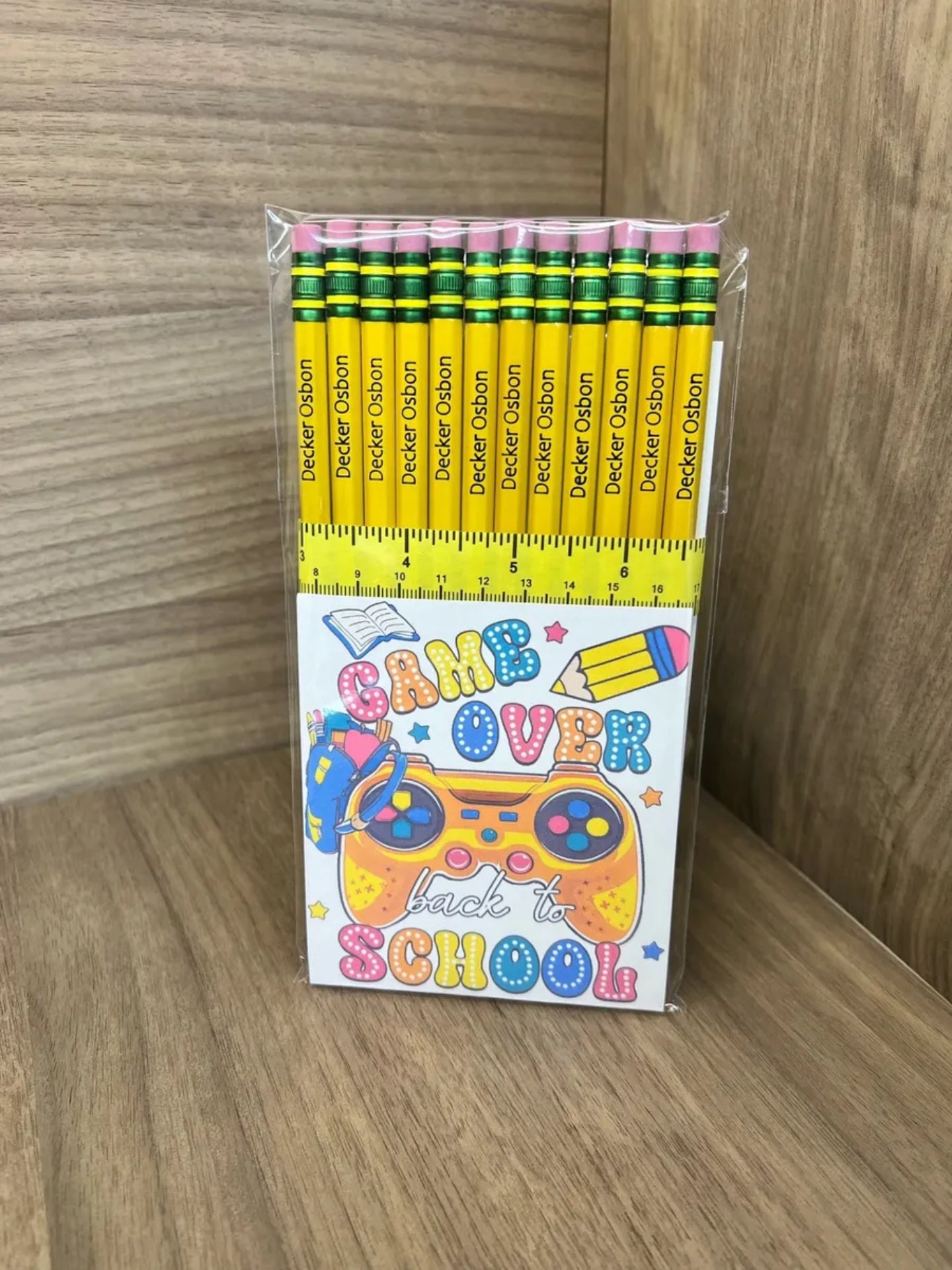 Pack of yellow pencils with a 'Back to School' themed box on a wooden surface