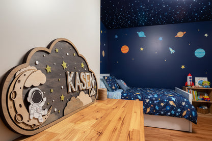 Wooden wall decor with 'KASEN Cole' and space-themed illustrations on a wooden surface.
