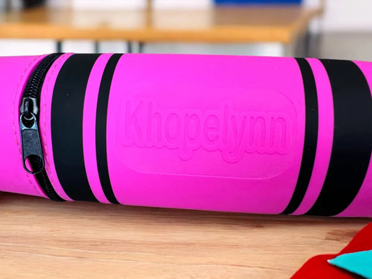 Pink and black pencil Case 'Khopelynn' branding on a wooden surface