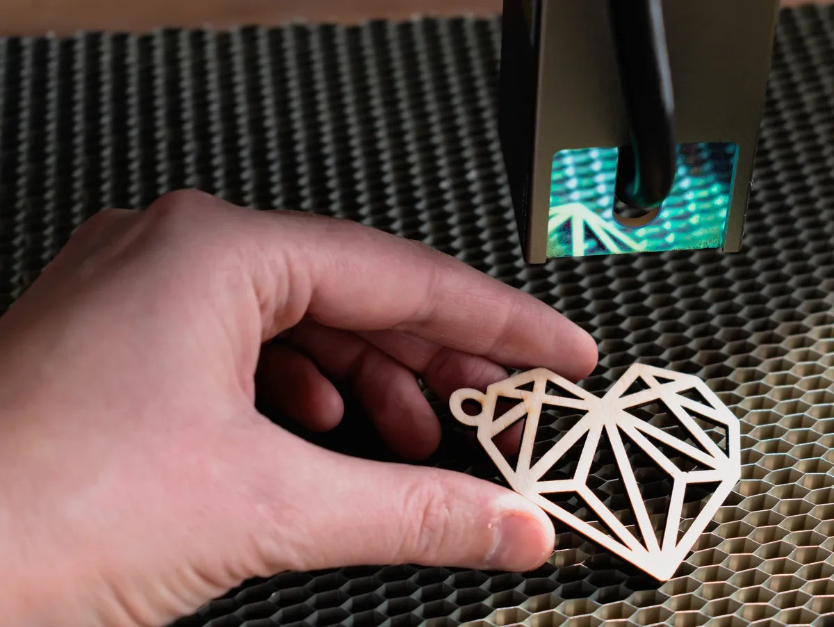 Hand holding a geometric heart-shaped object on a textured surface