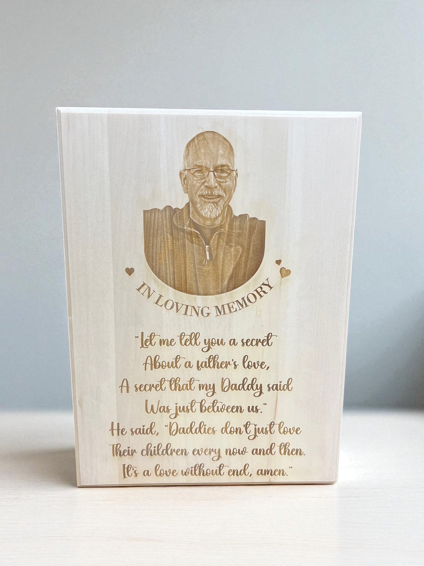 Wooden plaque with engraved portrait and text on a white background