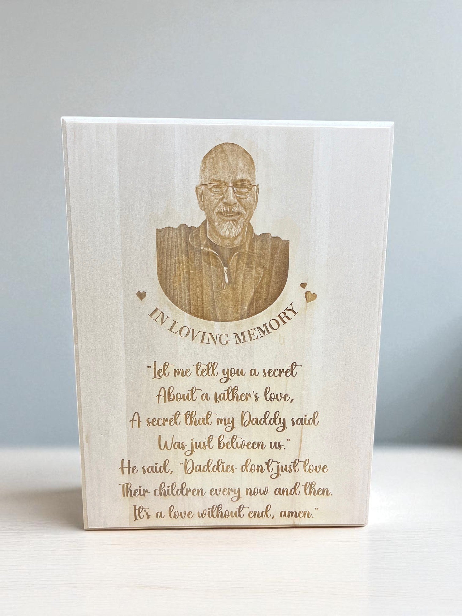 Wooden plaque with engraved portrait and text on a white background