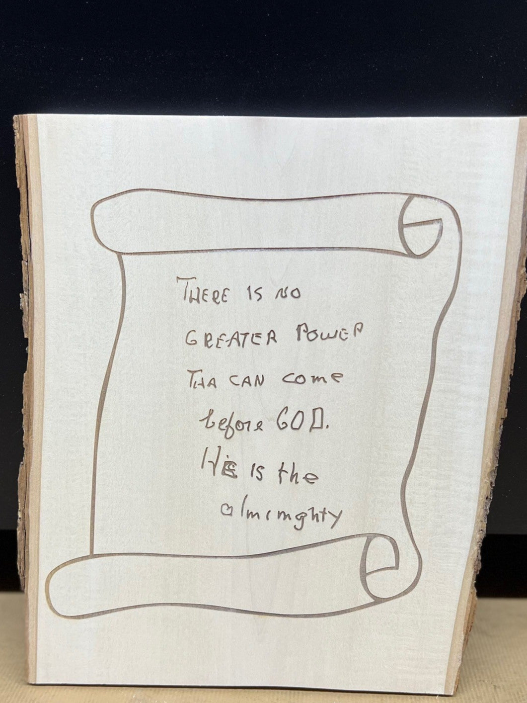 Wooden plaque with engraved text on a black background