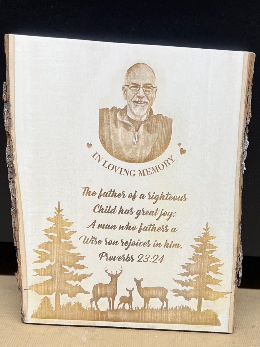 Memorial plaque with engraved text and illustrations on a wooden block.